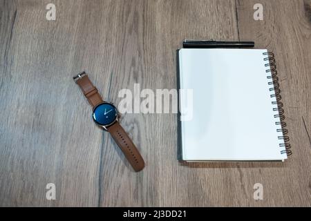 montre classique sur une table rustique avec espace pour le texte sur un bloc-notes blanc Banque D'Images