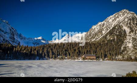 Paysage de montagne avec tarn gelé en hiver. Le lac de Popradske pleso dans le parc national des Hautes Tatras, Slovaquie, Europe. Banque D'Images