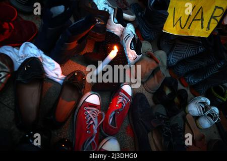 Sofia, Bulgarie - 7 avril 2022 : un panneau de guerre et une bougie sont visibles parmi les chaussures laissées dans les escaliers devant le centre culturel et d'information russe lors d'une manifestation en faveur de l'Ukraine. Le 24th février, l'armée russe est entrée en territoire ukrainien dans ce que le président russe Vladimir Poutine a déclaré comme une « opération militaire spéciale ». Banque D'Images