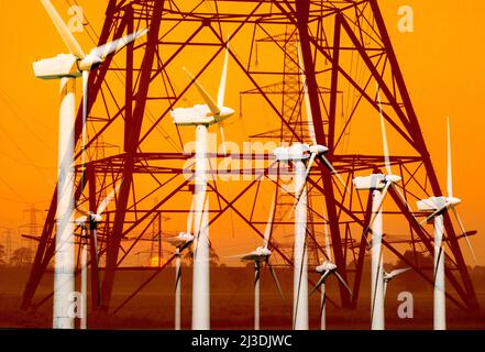 Pylônes d'électricité/lignes électriques avec éoliennes superposées au lever du soleil. Énergie propre et renouvelable, éoliennes terrestres, crise du coût de la vie au royaume-uni Banque D'Images