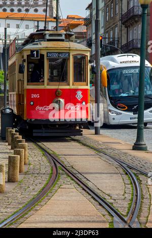 Porto tram 205 à côté d'un bus à l'arrêt Igreja de Sao Francisco dans le centre-ville de Porto au Portugal. Banque D'Images
