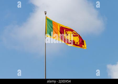 Drapeau du Sri Lanka également appelé le drapeau de Sinha ou le drapeau du lion est sur un mât sous ciel nuageux, un jour ensoleillé Banque D'Images