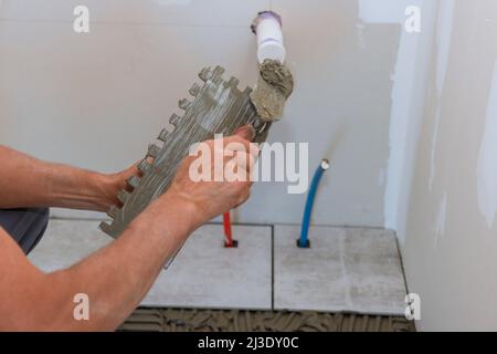 Maison de construction de travail avec placer des carreaux de sol en céramique Banque D'Images