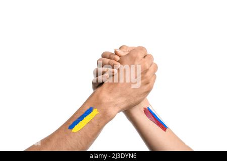 Tenant les mains des hommes et des femmes avec des drapeaux peints de l'Ukraine et de la Russie sur fond blanc Banque D'Images