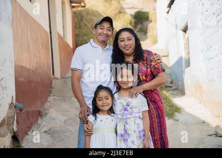 Famille hispanique à l'extérieur de leur maison - famille guatémaltèque dans la ruelle de leur quartier Banque D'Images