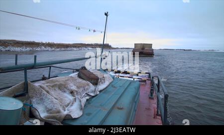 Vue depuis le navire sur une remorque de barge avec des marchandises. Attache. Concept de transport d'eau, conteneurs sur une barge et une rivière large. Banque D'Images