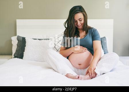 Être enceinte est du pur bonheur. Photo d'une jeune femme enceinte se détendant à la maison. Banque D'Images