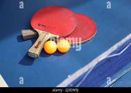 SURABAYA, INDONÉSIE - 06 MARS 2020 : deux raquettes et balles de tennis de table ou de ping-pong sur une table et un filet bleus Banque D'Images