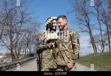 Kiev, Ukraine. 07th avril 2022. Les jeunes mariés en uniforme militaire avec mitrailleuses et un bouquet de mariage posent pour une photo mémorable le jour de leur mariage. Membres de la Défense territoriale de Kiev, Anastasiia Mokhina, 24 ans, et Viacheslav Hohlyuk, 43 ans, Marié aujourd'hui sous les lois de la loi martiale à Kiev, Ukraine. Crédit : SOPA Images Limited/Alamy Live News Banque D'Images