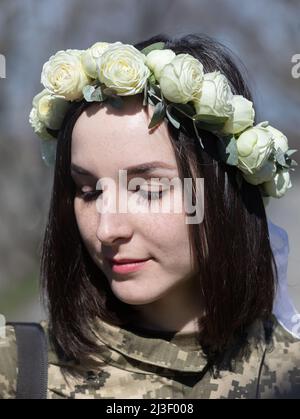 Kiev, Ukraine. 07th avril 2022. Portrait d'une mariée en uniforme militaire et avec un bouquet de roses blanches. Membres de la Défense territoriale de Kiev, Anastasiia Mokhina, 24 ans, et Viacheslav Hohlyuk, 43 ans, Marié aujourd'hui sous les lois de la loi martiale à Kiev, Ukraine. Crédit : SOPA Images Limited/Alamy Live News Banque D'Images