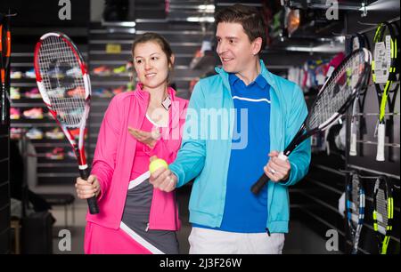 Femme et homme en uniforme choisissant la fusée de tennis Banque D'Images