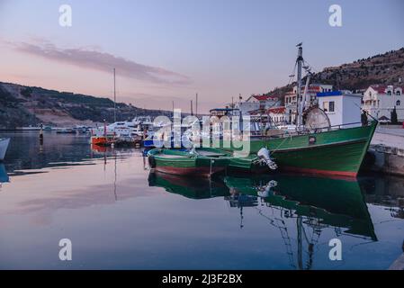 Vue sur les bateaux dans la baie de Balaklava près de la jetée au printemps au coucher du soleil. Crimée Banque D'Images