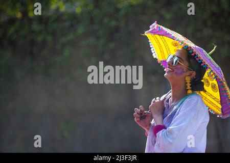 Portrait d'une jeune femme heureuse à la recherche d'un autre endroit avec parasol et lunettes de soleil Banque D'Images