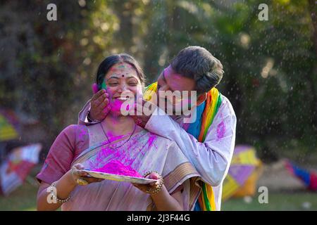 Joyeux couple d'âge moyen célébrant l'Holi avec des couleurs sèches Banque D'Images