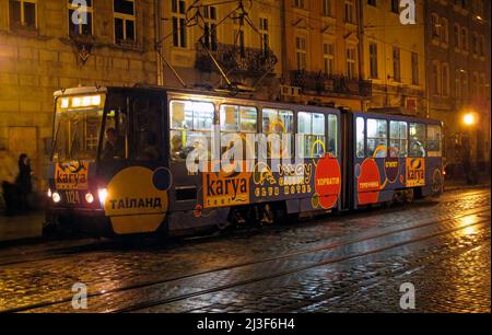 Service de tramway la nuit sous la pluie, place Rynok, centre-ville, Lviv, Ukraine Banque D'Images