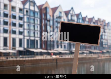 Blanc panneau noir contre l'architecture de construction d'appartement nouvelle dans la vieille ville Gdansk modèle de maquette vide marque de tableau noir Gdansk Pologne ville. Déplacement Banque D'Images