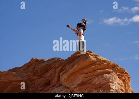 Jeune père portant son bébé sur ses épaules et prenant un selfie sur une falaise, les chaînes, page, Arizona. Banque D'Images
