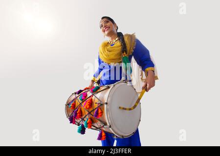 Portrait de la femme sikh jouant au tambour pendant la célébration Baisakhi Banque D'Images