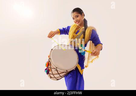 Portrait de la femme sikh jouant au tambour pendant la célébration Baisakhi Banque D'Images