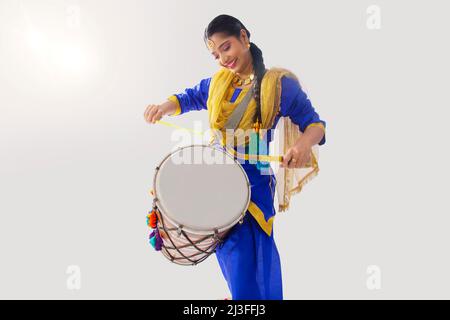 Portrait de la femme sikh jouant au tambour pendant la célébration Baisakhi Banque D'Images