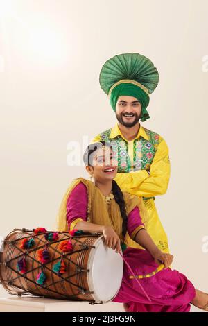 Portrait de femme de couple sikh en tenue traditionnelle appréciant à l'occasion de Baisakhi Banque D'Images