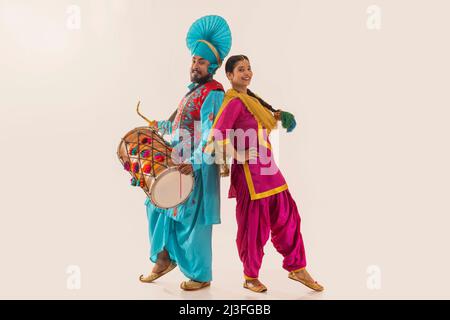 Le couple Sikh exécutant bhangra et jouant au tambour pendant la fête de Baisakhi Banque D'Images