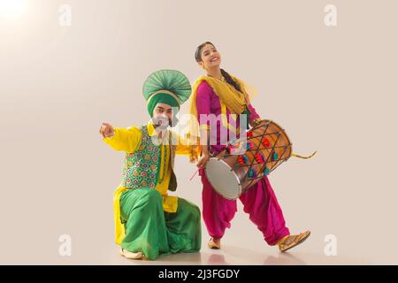 Le couple Sikh exécutant bhangra et jouant au tambour pendant la fête de Baisakhi Banque D'Images