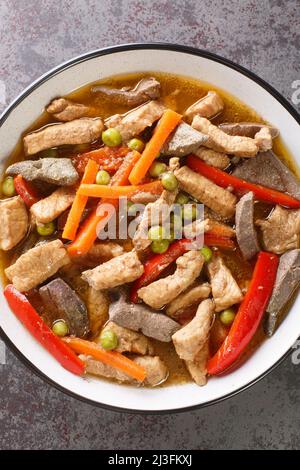 La nourriture philippine Igado est un plat Ilocano populaire fait de filet de porc et d'innards avec des légumes dans l'assiette sur la table. Vertical haut vi Banque D'Images