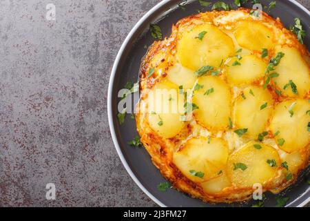 Les pommes de terre hachées à la poêle sont accompagnées de tranches de pommes de terre, d'oignons sautés, recouverts de fromage Dubliner dans l'assiette de la table. Vue horizontale du dessus à partir de Banque D'Images