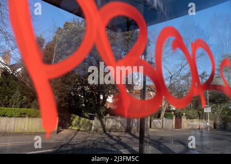 Graffiti est écrit en peinture rouge vif sur un abri d'autobus dans le village de Dulwich, dans le sud de Londres, le 2nd avril 2022, à Londres, en Angleterre. Banque D'Images