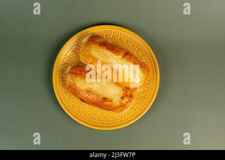 Pain sucré brésilien de la boulangerie sur une assiette jaune et un fond vert Banque D'Images