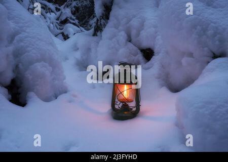 Lanterne d'époque brûlante dans la forêt de nuit d'hiver. Magnifique arrière-plan d'hiver. Banque D'Images