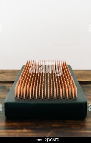 un tableau sadhu en chêne foncé avec clous en cuivre sur un plancher en bois. la pratique yogique de se tenir sur des ongles Banque D'Images