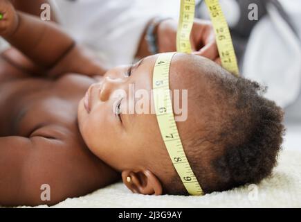 Vous allez être un bébé intelligent. Prise de vue d'un bébé dont la tête est mesurée par un médecin. Banque D'Images