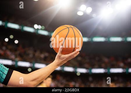 arbitre tenant le ballon de basket pendant le match Banque D'Images