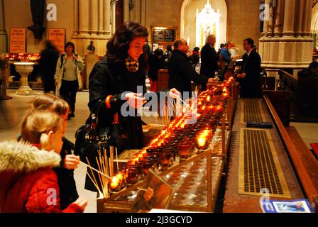 Une mère et ses filles illuminaient les bougies de prière à la cathédrale Saint-Patrick de New York Banque D'Images