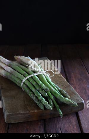 Asperges fraîches isolées sur fond de bois. Gros plan. Une alimentation saine. Nourriture de printemps. Banque D'Images
