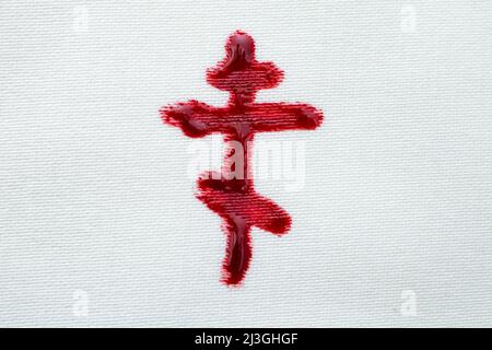 Crucifix orthodoxe scribbled avec du sang sur la texture de tissu blanc Banque D'Images