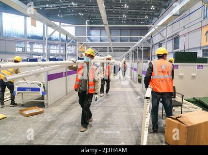 (220408) -- SHANGHAI, le 8 avril 2022 (Xinhua) -- les travailleurs travaillent sur le site de construction d'un hôpital temporaire au National Exhibition and Convention Centre (Shanghai), dans l'est de la Chine, Shanghai, le 8 avril 2022. Shanghai a ouvert et continuera de construire davantage d'hôpitaux temporaires pour améliorer la capacité de traitement de la ville pour les infections COVID-19 dans sa dernière résurgence COVID-19, ont déclaré vendredi les autorités. Quatre hôpitaux temporaires municipaux, trois situés dans le district de Pudong et un dans le district de Chongqing, ont été mis en service vendredi. Couvrant un total de 500 000 mètres carrés Banque D'Images