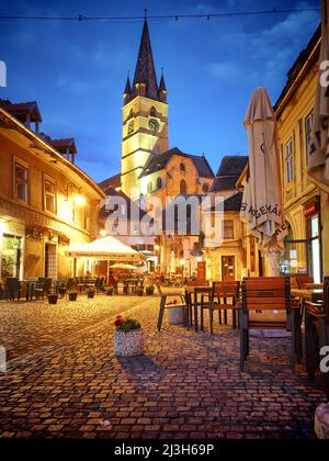 SIBIU, ROUMANIE - 30 juillet 2018 : Cathédrale luthérienne de la rue médiévale de la vieille ville la nuit Banque D'Images