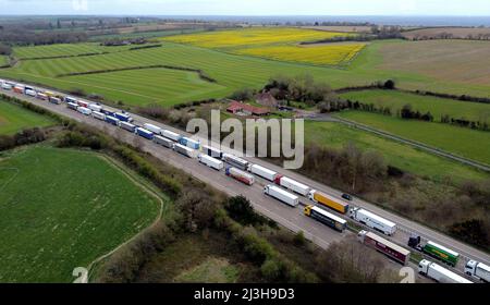 Une vue des camions placés dans la file d'attente de l'opération Brock sur la M20 près d'Ashford dans le Kent, les retards de fret se poursuivent au port de Douvres où les services de ferry P&O restent suspendus après que l'entreprise ait mis à pied 800 employés sans préavis. Date de la photo: Vendredi 8 avril 2022. Banque D'Images