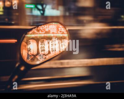 Réflexions de lanternes et de panneaux dans un miroir à vue latérale, avec des pistes lumineuses en arrière-plan, Taipei Banque D'Images