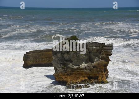 Une vue panoramique sur l'océan mousseux, le surf et les piles de la mer juste à côté de la plage aux populaires Punakaiki Pancake Rocks sur l'île sud de la Nouvelle-Zélande. Banque D'Images