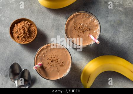Une banane au chocolat maison saine et une smoothie dans un verre Banque D'Images