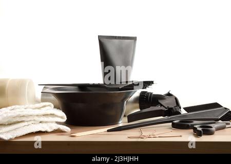 Accessoires et préparation de produits pour le traitement des cheveux sur table en bois et fond blanc isolé. Vue avant. Composition horizontale. Banque D'Images