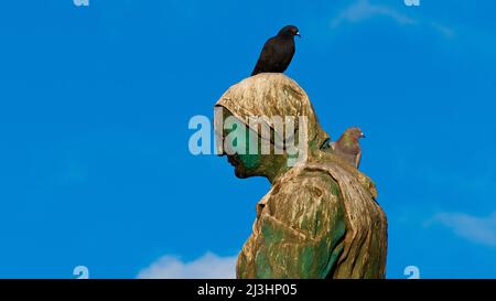 Espagne, îles Canaries, Fuerteventura, capitale, Puerto del Rosario, monument, figure de bronze, sur la tête se trouve un oiseau, bleu ciel, nuages blancs simples Banque D'Images