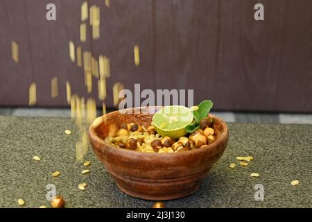 fermer les lentilles frit de gramme jaune avec du gramme noir et des tranches de citron, menthe dans le bol en bois rouge sur un fond brun hors foyer. Banque D'Images