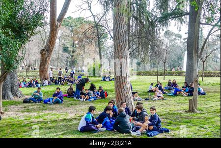 Les jeunes enfants sont assis sur le terrain à El Retiro Park, Madrid, Espagne Banque D'Images