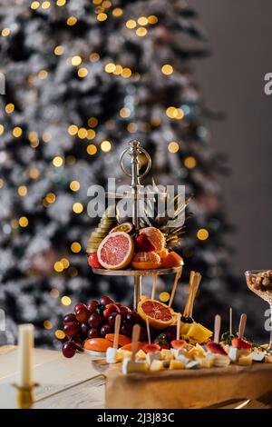 Arbre de Noël aux fruits sur table sur fond sombre. Banque D'Images