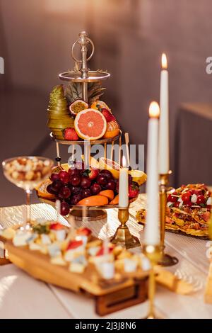 Assortiment de fruits sains et de petits fruits, fraises framboises fond plateau prunes raisins Oranges Pommes kiwis bleuets, mangues, top vi Banque D'Images